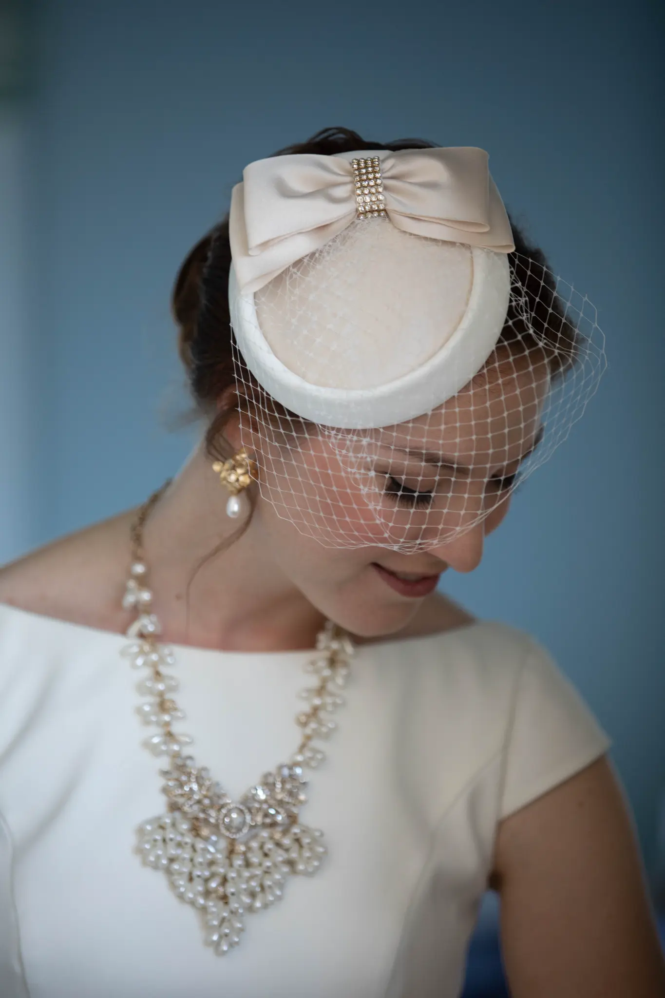 Emily in bridal fascinator hat with birdcage veil