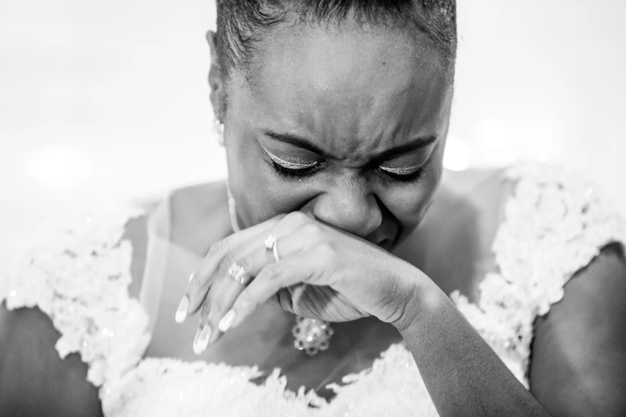 Bride overcome with emotion, hands pressed to her face in a raw unguarded moment
